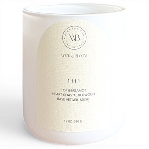 Wick & Bloom 11 11 wood wick candle in white vessel, label showing bergamot, redwood, vetiver and musk notes
