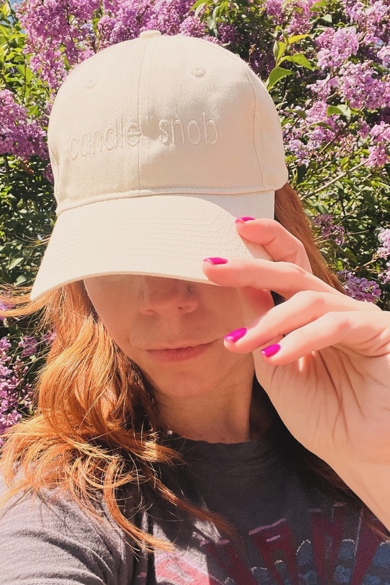 Wick & Bloom "Candle Snob" embroidered cap in cream, worn by a model